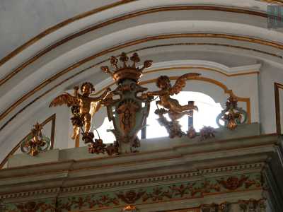 Il frontone imponente chiude il tutto ed � a sua volta sormontato da putti alati che sorreggono lo stemma incoronato dei carmelitani